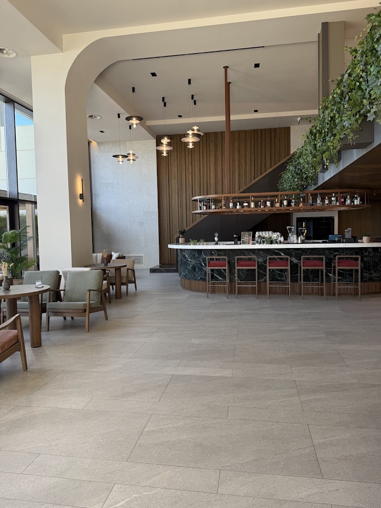 Curved marble lobby bar with pendant lighting and timber panelling