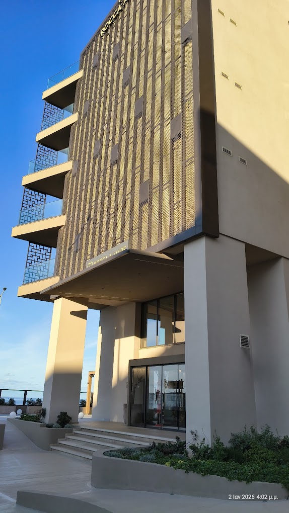 Hotel entrance beneath the perforated metal screen facade in afternoon light