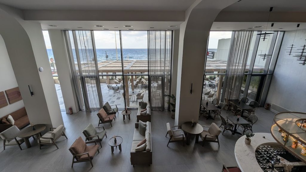 Hotel lobby seating with sheer curtains and sea views beyond